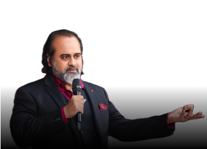 Acharya Prashant speaking into a microphone with his hand extended